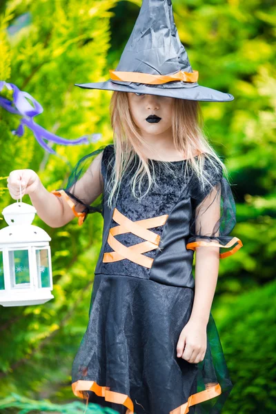 Adorable niña con disfraz de bruja en Halloween en el día de otoño. Truco o trato . —  Fotos de Stock