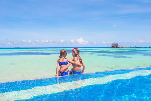 Adorable little girls in outdoor swimming pool on vacation — Stock Photo, Image