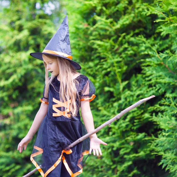 Little girl with broom wearing witch costume on Halloween. Trick or treat. — Stock Photo, Image