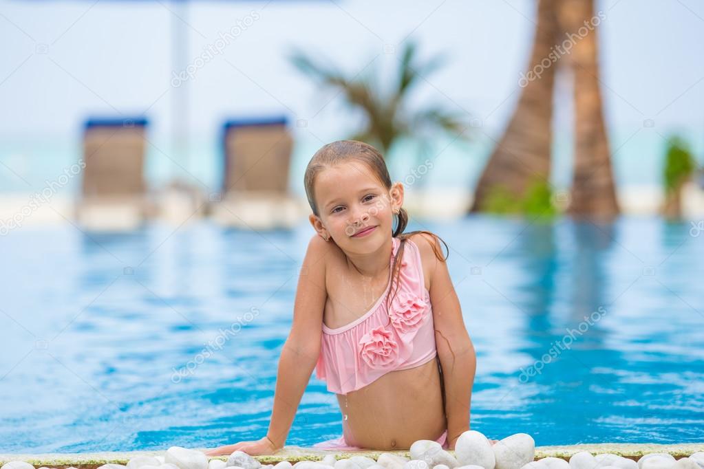 Little happy cute girl in outdoor swimming pool