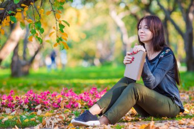 Genç kadın güzel sonbahar park bir kitap okuma