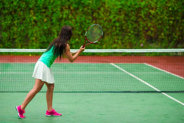 Joven mujer deportiva activa jugando al tenis en vacaciones tropicales —  Fotos de Stock