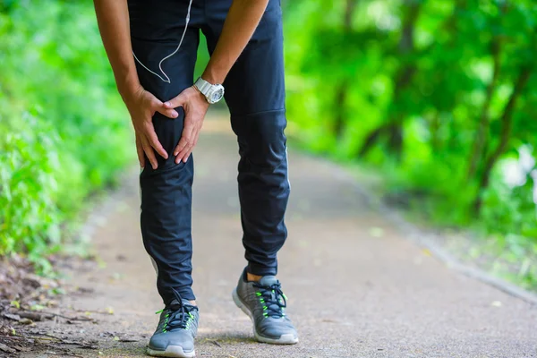 Atleta masculino que sufre de dolor en la pierna mientras hace ejercicio al aire libre —  Fotos de Stock