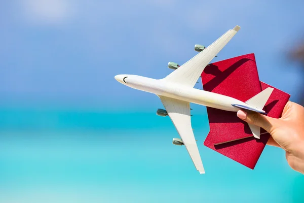 Primo piano dei passaporti e bianco miniatura aeroplano sfondo il mare turchese — Foto Stock