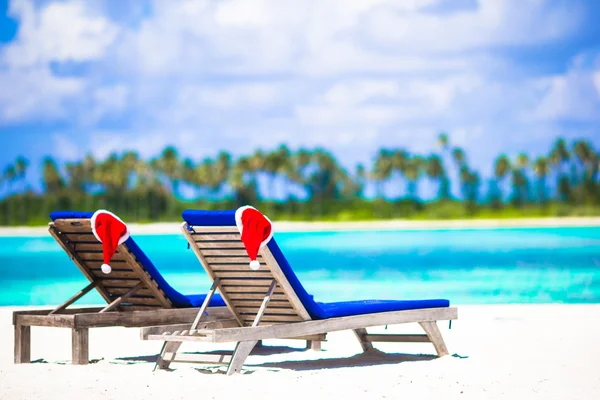 Red santa hats on chair longue at tropical white beach — Stock Photo, Image