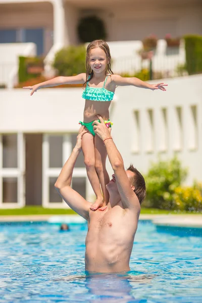 Menina e feliz pai se divertindo juntos na piscina ao ar livre — Fotografia de Stock