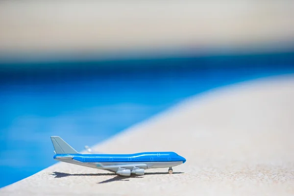 Small white miniature of an airplane on background of pool — Stock Photo, Image