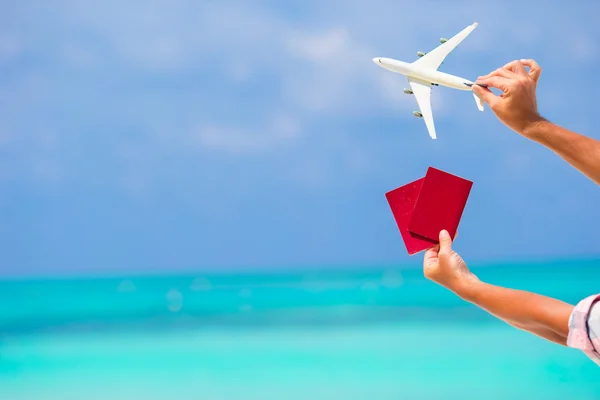 Primer plano de pasaportes y fondo de avión blanco en miniatura el mar turquesa — Foto de Stock