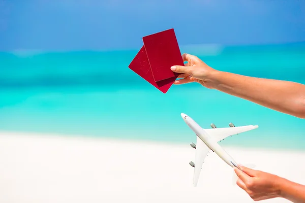 Closeup of passports and white miniature airplane background the turquoise sea — Stock Photo, Image