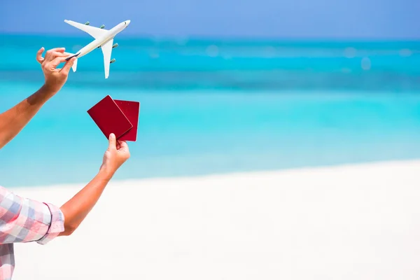 Closeup of passports and white miniature airplane background the turquoise sea — Stock Photo, Image