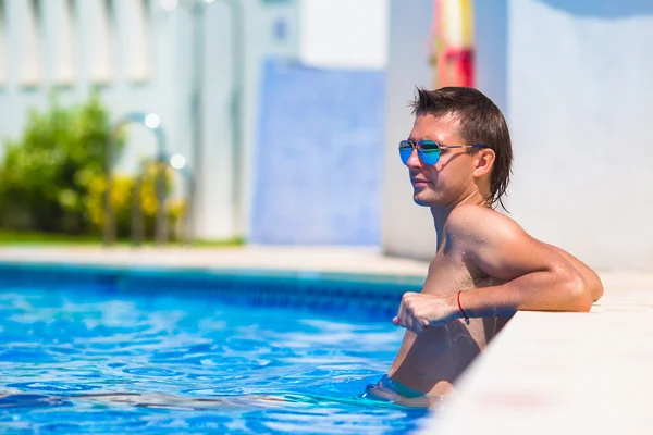 Giovane uomo felice rilassarsi in piscina all'aperto — Foto Stock