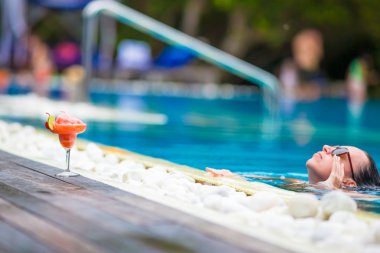 Güzel genç kadın lüks yüzme havuzunda rahatlatıcı