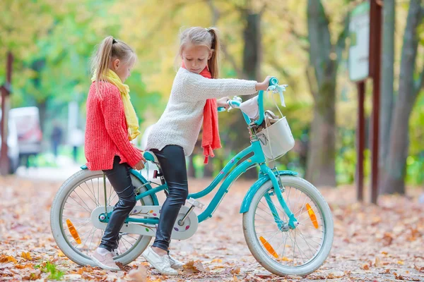 Adorables niñas montando una bicicleta en un hermoso día de otoño al aire libre —  Fotos de Stock