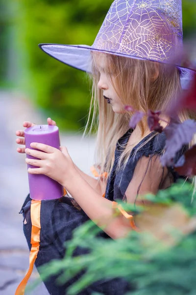 Halloween y adorable niña con vela vestida de bruja —  Fotos de Stock