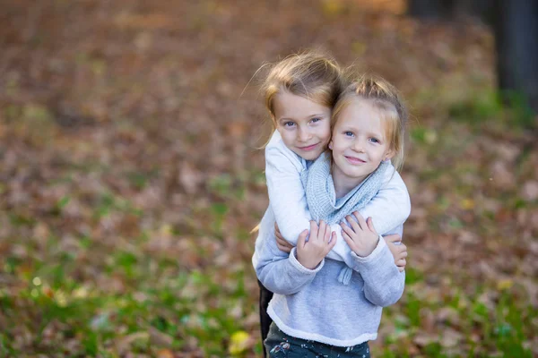 Kleine meisjes plezier in mooie herfst park buiten — Stockfoto