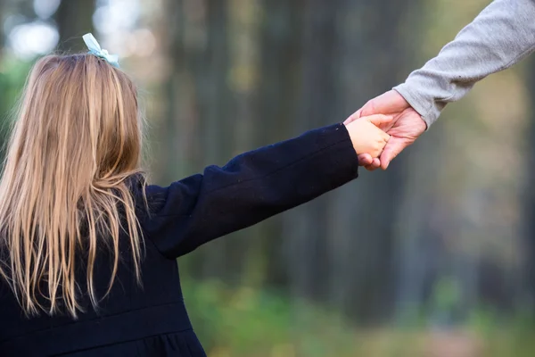 Closeup hands of little girl with dad in beautiful autumn park — Stock Photo, Image