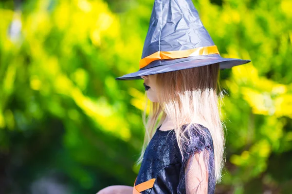 Adorable little girl in witch costume on Halloween at autumn day. Trick or treat. — Stock Photo, Image