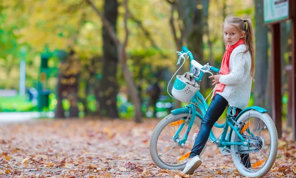 Bedårande flicka rida en cykel på vacker höstdag utomhus — Stockfoto