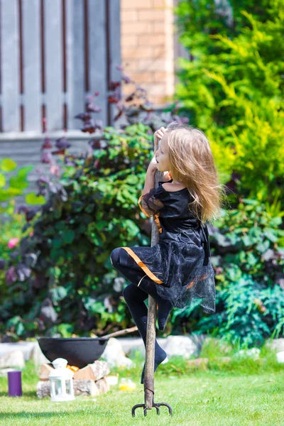 Adorable niña con disfraz de bruja en Halloween en el día de otoño. Truco o trato . — Foto de Stock