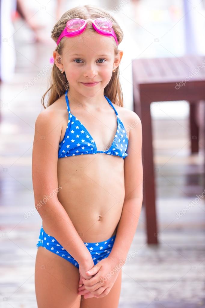Little adorable girl having fun in outdoor swimming pool