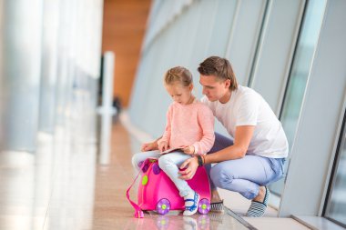 Mutlu dada ve küçük kız yatılı ile havaalanında uçuş bekleyen terminal geçmek