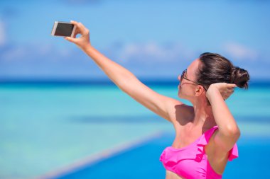 Selfie telefon ile açık havada plaj tatil sırasında alarak genç güzel kadın