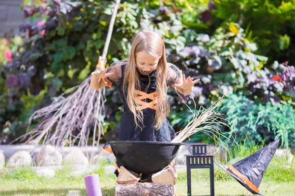 Happy little witch have fun outdoors on Halloween. Trick or treat. — Stock Photo, Image