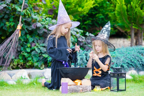 Happy little witches have fun outdoors on Halloween. Trick or treat. — Stock Photo, Image