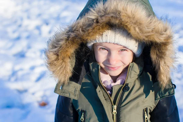 Kleines entzückendes Mädchen mit schönen grünen Augen im Schnee sonnigen Wintertag — Stockfoto