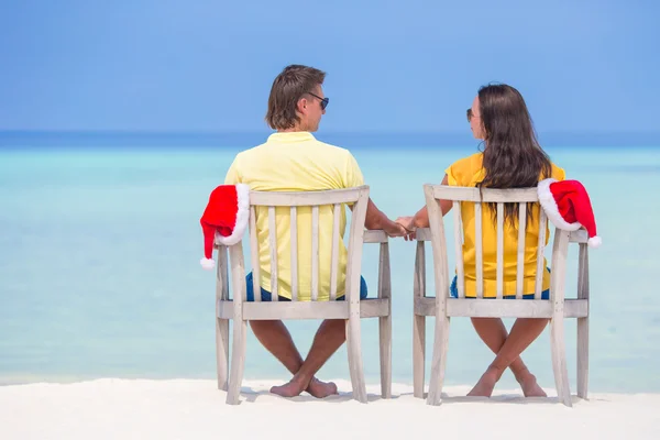 Ung familj två i Santa hattar avkopplande på tropical beach under jullovet — Stockfoto