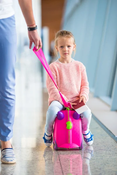 Bedårande liten flicka har kul på flygplatsen sitter på resväska — Stockfoto