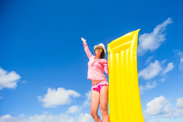 Молодая счастливая женщина отдыхает с надувным матрасом на пляже — стоковое фото