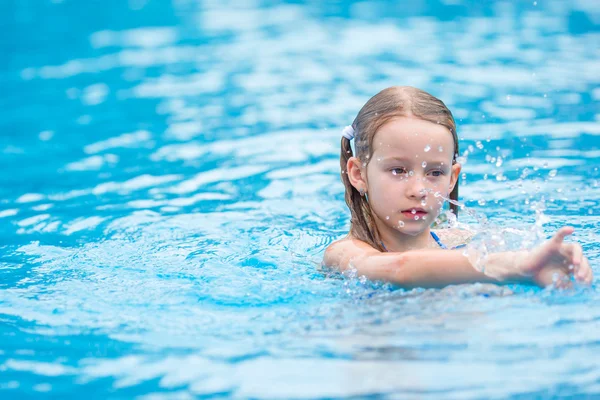Adorable little girl having fun in outdoor swimming pool — Stock Photo, Image