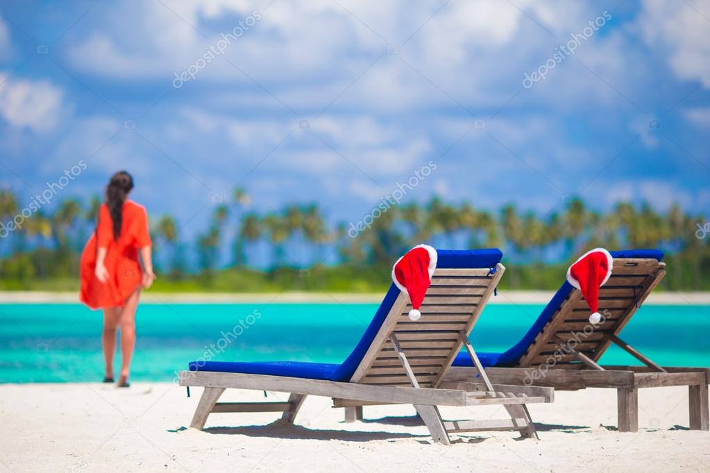 Christmas hats on beach loungers at white beach in Maldives