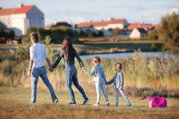 Famiglia felice con valigia che cammina all'aperto — Foto Stock