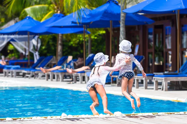 Adorables niñas divirtiéndose en la piscina al aire libre en las vacaciones de verano —  Fotos de Stock