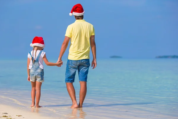 Klein meisje en blij vader in Kerstman hoed tijdens strand vakantie van Kerstmis — Stockfoto