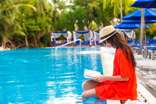 Giovane ragazza lettura libro rilassante in piscina — Foto Stock