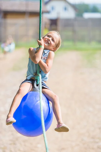 Adorável menina se divertindo em um balanço ao ar livre — Fotografia de Stock