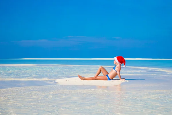 Little cute girl in Santa hat on white beach during vacation — Stock Photo, Image