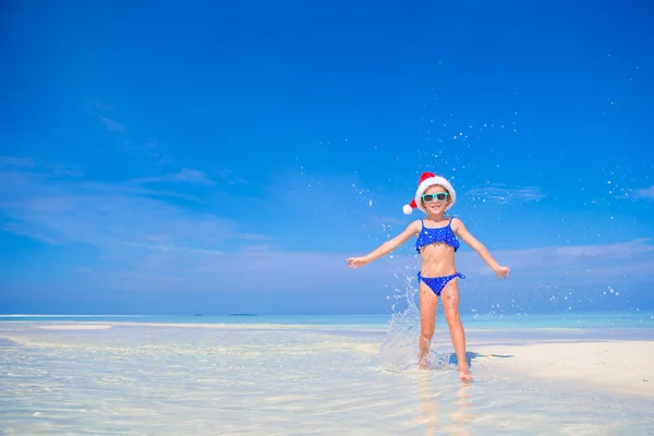 Pequena menina feliz em chapéu de Santa durante as férias na praia em Maldivas — Fotografia de Stock