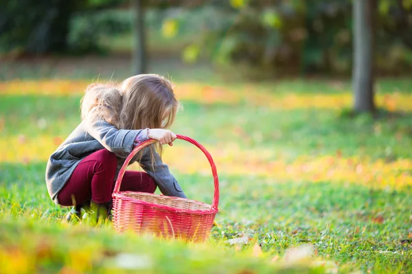 Adorable little girl with a basket in cold autumn day outdoors — Stock Photo, Image