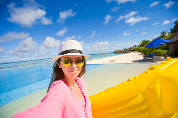 Young happy woman relaxing with air mattress during tropical vacation — Stock Photo, Image