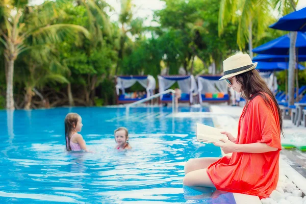 Giovane ragazza lettura libro rilassante in piscina — Foto Stock