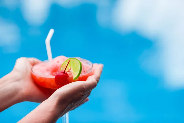 Tasty cocktail in female hands background turquoise sea — Stock Photo, Image