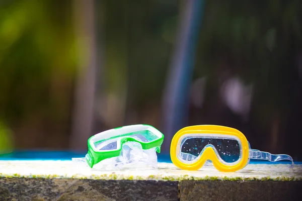 Dos máscaras de buceo húmedas tiradas cerca de la piscina — Foto de Stock