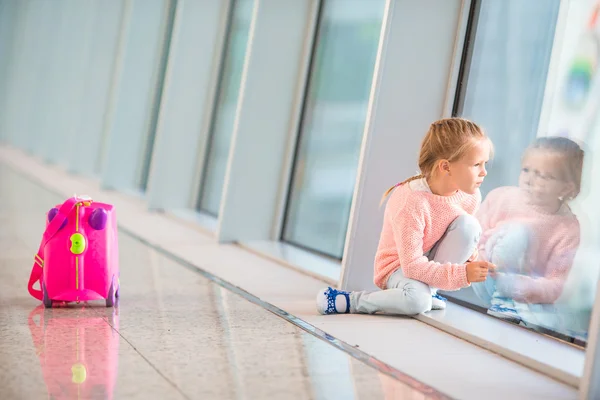 Söt liten flicka på flygplatsen med sitt bagage väntar på ombordstigning — Stockfoto