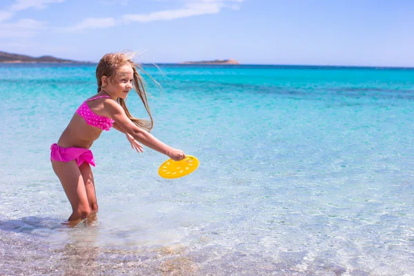 Niña adorable jugando frisbee durante las vacaciones tropicales —  Fotos de Stock