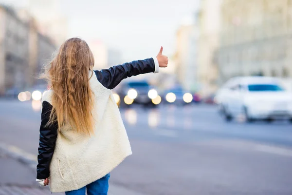 Adorable little girl get taxi outdoors in European city