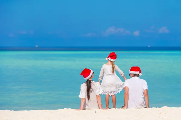 Junge Familie mit Weihnachtsmützen im Weihnachtsurlaub — Stockfoto